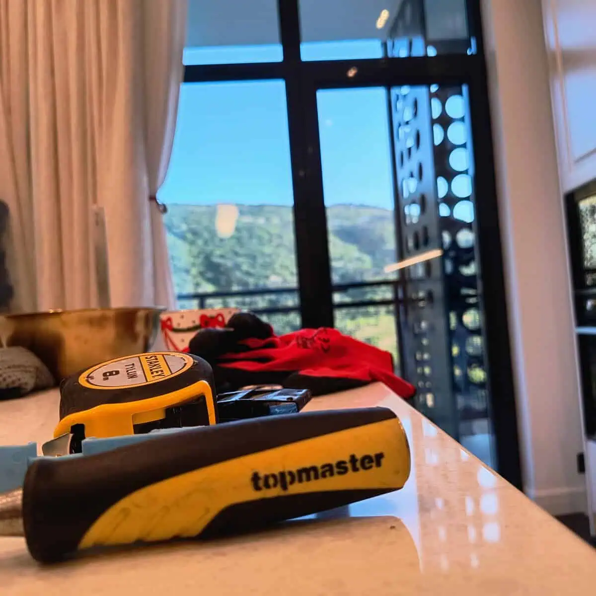 Stanley tape measure and Topmaster bead remover on a worktop before measuring a window in Tbilisi