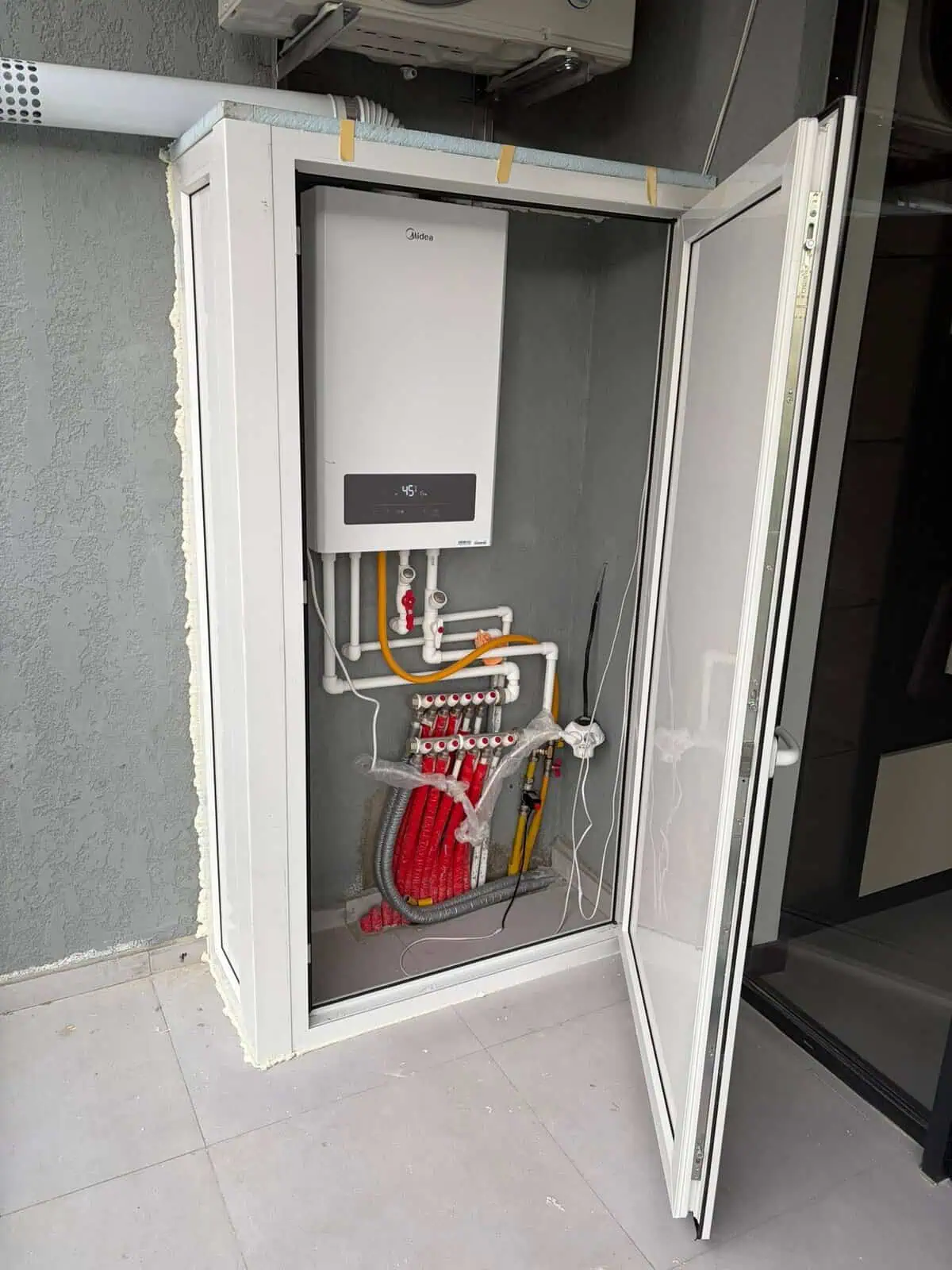 Пластиковый шкаф из ПВХ для защиты газового котла и труб коллектора отопления на открытом балконе в Тбилиси