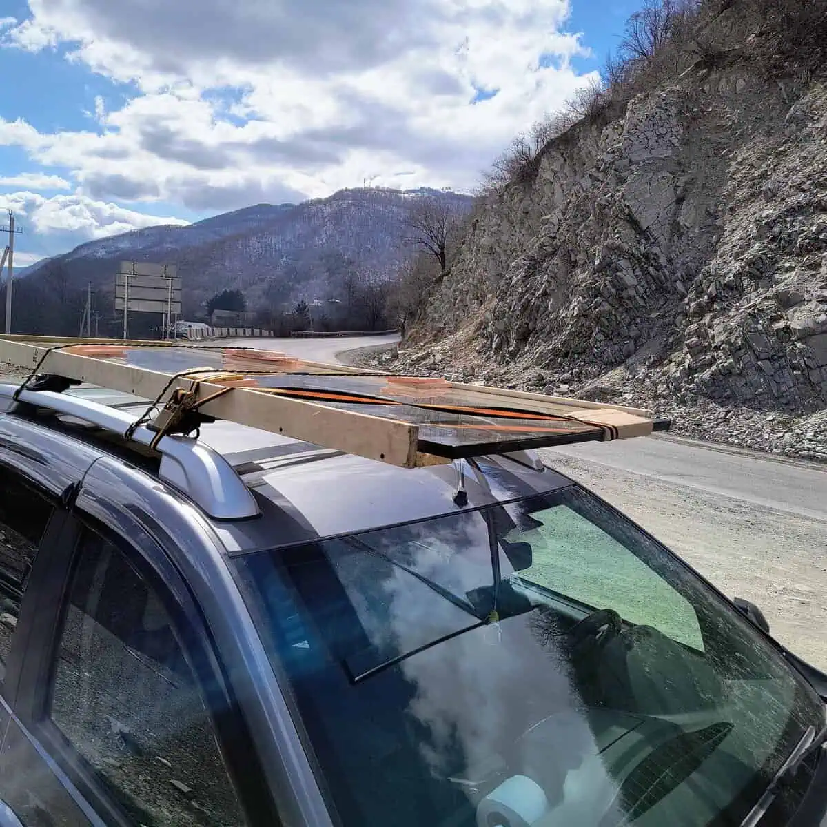 Double-glazed unit secured to a car roof rack on a mountain road near Gudauri Georgia